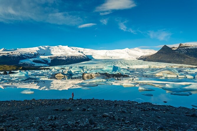 A glacier tongue spilling off the ice cap into a lagoon full of icebergs